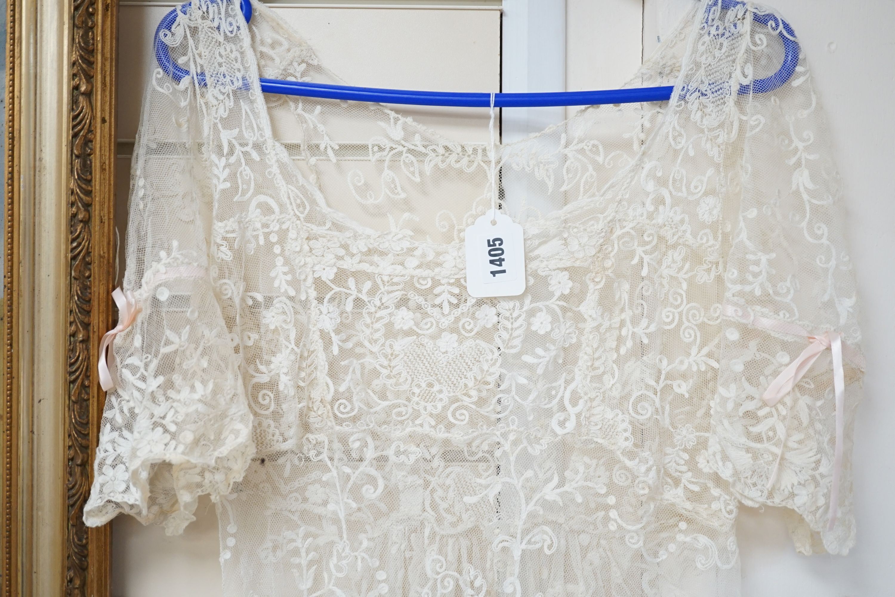 An early 20th century needle run on net lace wedding dress, 155 cms long.